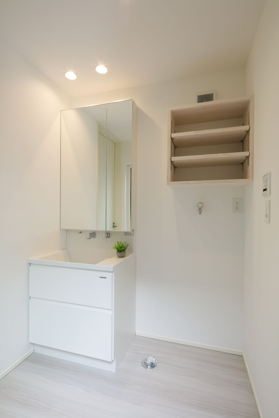 【洗面室】清潔感のある洗面室。洗濯機上部にしっかり収納できる造作棚つき